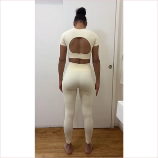 Cream-colored bubble gum top workout set with cropped top back oval cutout and high-waisted leggings
