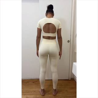 Cream-colored bubble gum top workout set with cropped top back oval cutout and high-waisted leggings